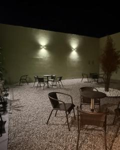 a group of chairs and tables in a room at night at Hostel em Jaguarão in Jaguarão