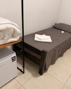 a small bed in a room next to a bunk bed at Hostel em Jaguarão in Jaguarão