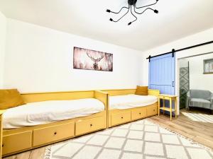 two beds in a room with white walls at Kökény Kunyhó in Kisszékely