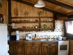 a kitchen with wooden cabinets and a sink and a stove at Home Hotel in Kamianets-Podilskyi