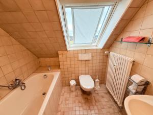 a bathroom with a tub and a toilet and a sink at Ferienhaus Frei 3 Budget in Titisee-Neustadt +25 photos