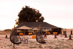 a tent with chairs and tables in front at Maria'S Luxury Camp in Merzouga
