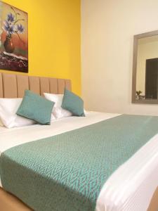 a bedroom with a large bed with two blue pillows at HOTEL CATALUÑA PEREIRa in Pereira