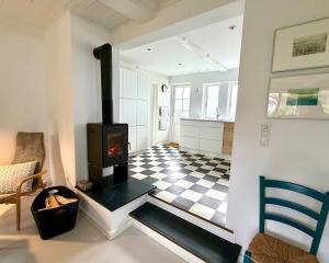 a living room with a fireplace and a checkered floor at Beachhouse Humlebæk in Humlebæk