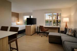 a hotel room with a bed and a couch and a desk at Residence Inn Phoenix Mesa in Mesa