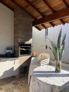 a kitchen with a table and a counter with a stove at Pousada e Edícula in Jabuticabal