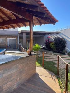 a backyard with a wooden fence and a wooden pergola at Pousada e Edícula in Jabuticabal