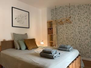 a bedroom with a bed with towels on it at Cocon de douceur en centre ville in Le Puy-en-Velay