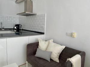 a living room with a couch and a kitchen at Estudio Vista Mar & Piscina - 200 m de la playa in Aguadulce