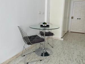 a glass table and two chairs in a room at Estudio Vista Mar & Piscina - 200 m de la playa in Aguadulce