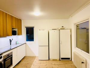 two white refrigerators in a kitchen with a window at COZY ROOM - between Malmö & Lund in Lund