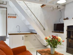 a living room with a vase of flowers on a table at Hogwood Cottage in Knaresborough