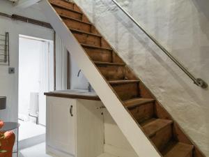 a staircase in a living room with wooden stairs at Hogwood Cottage in Knaresborough
