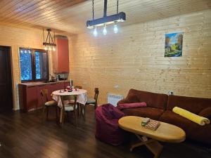 a living room with a couch and a table at Tatu's wooden hut in Mestia +13 photos