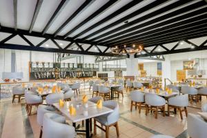 a dining room with white tables and chairs at Royal Solaris Los Cabos - All Inclusive in San José del Cabo