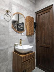 a bathroom with a sink and a mirror at Tatu's wooden hut in Mestia