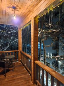 a room with a balcony with a view of the water at Tatu's wooden hut in Mestia