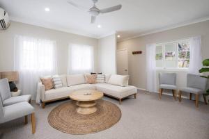 a living room with a couch and a table and chairs at Glass House Cottage in Glass House Mountains