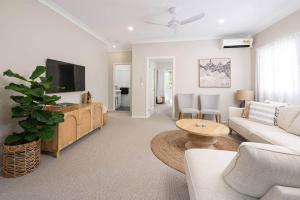 a living room with a couch and a tv at Glass House Cottage in Glass House Mountains