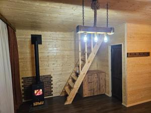 a room with a woodburning stove and a wooden wall at Tatu's wooden hut in Mestia