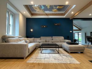 a living room with a couch and a blue wall at Le Domaine Endila in Munster