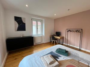 a bedroom with a bed and a desk in it at Le Domaine Endila in Munster