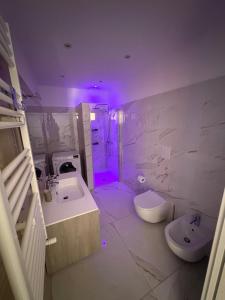 a bathroom with a sink and a toilet and purple lights at Casa del maresciallo in Giovinazzo