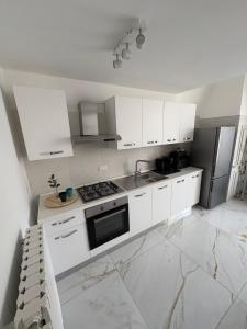 a white kitchen with white cabinets and a stove at Casa del maresciallo in Giovinazzo +5 photos