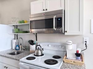 a kitchen with a stove and a microwave at Suite One King Bed 2TVs Free Parking & museums in Richmond +7 photos