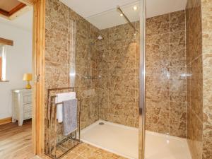 a bathroom with a shower with a glass door at Stoney Cottage in Narberth +18 photos