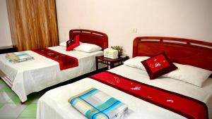 two beds in a room with red and white sheets at Xuân Thành Homestay in Vũ Lâm