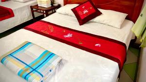 a bedroom with two beds with red and white sheets at Xuân Thành Homestay in Vũ Lâm