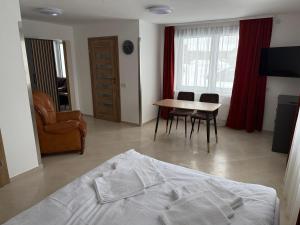 a bedroom with a bed and a table and chairs at SALGIRDO svečių namai in Kelmė