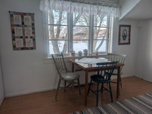 a dining room with a table and chairs and a window at Borghildstua Feriehus Romslig feriehus med panoramautsikt mot havet og Lofotfjellene in Melbu