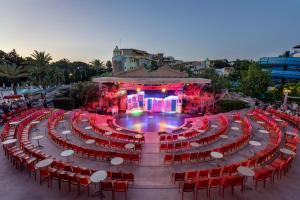 a large amphitheater with red chairs and a stage at Limak Arcadia Sport Resort Belek in Belek +132 photos