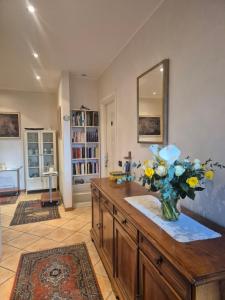 a vase of flowers on a wooden counter in a room at I Quattro Ulivi - Iseo Lake in Marone