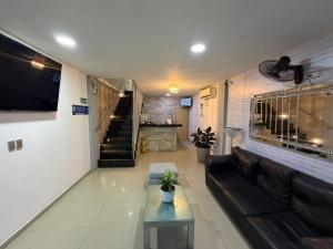 a living room with a couch and a tv at Hotel Babilonia Boutique in Cúcuta