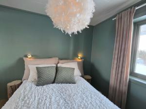 a bedroom with a bed and a chandelier at Fygle living in Vestvågøya