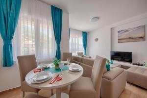 a dining room and living room with a table and chairs at Mir i More in Dobra Voda