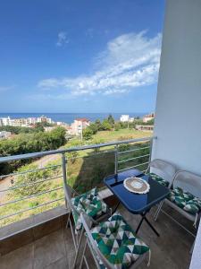 a balcony with a table and chairs and the ocean at Mir i More in Dobra Voda