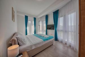 a bedroom with a bed with blue drapes at Mir i More in Dobra Voda +42 photos