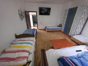 a bedroom with two beds and a hallway with a mirror at Matei Apartament in Tîrnăveni