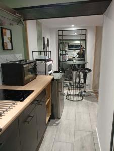 a kitchen with a counter and a person in the background at L'harmonie des Oiseaux in Meyronne +13 photos