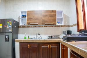 a kitchen with a sink and a refrigerator at Piazza Granada in Cali +13 photos