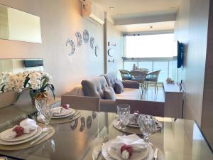 a living room with a couch and a glass table at Frente mar na praia de Itaparica! in Vila Velha