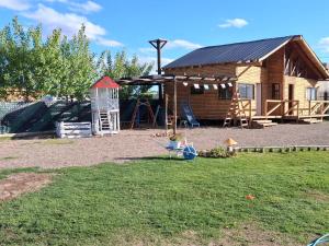 a log cabin with a playground in a yard at el sueño in Las Compuertas