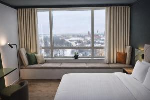 a bedroom with a bed and a large window at Holiday Inn Cottbus by IHG in Cottbus