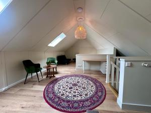 an attic room with a rug on the floor at Erve t Hoolterhof in Holten