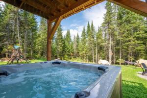 a hot tub in the middle of a yard at Le Kouzy - Spa, Foosball, Pool table, Game Room in Sainte-Lucie-de-Doncaster