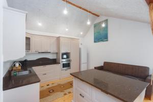 a kitchen with white cabinets and a black counter top at HomeRent Bucuresti Studio in Chişinău